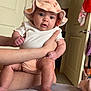 Eilani is registered to the contest to win money with this photo: baby, infant, hat, clothing, hands, person, indoor, door, bed, blanket, skin, cute, child, expression, apparel, human, face, leg, foot, room