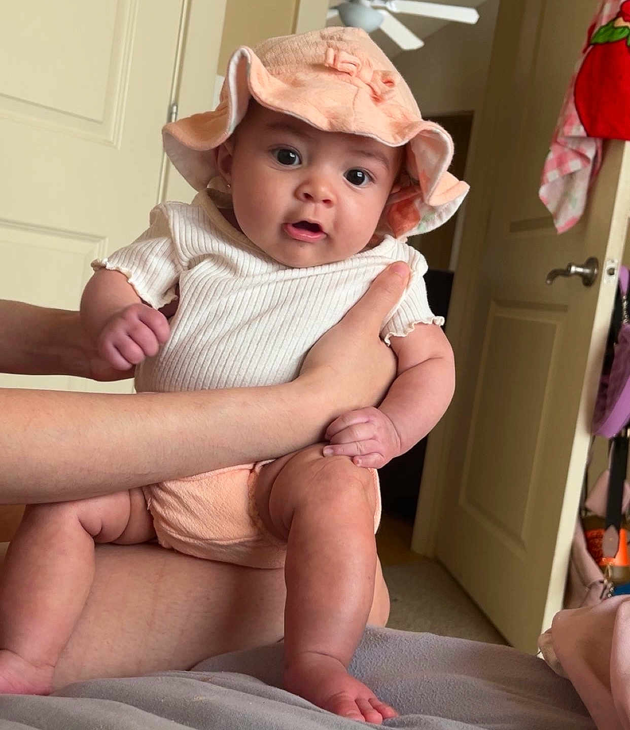 Eilani is registered to the contest to win money with this photo: baby, infant, hat, clothing, hands, person, indoor, door, bed, blanket, skin, cute, child, expression, apparel, human, face, leg, foot, room