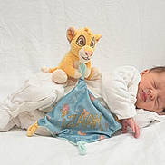Izaak a rejoint le concours — aidez-le/la à gagner de superbes lots ! baby, newborn, sleeping, plush_toy, simba, soft_toy, white_clothing, blanket, blue_cloth, name_tag, cute, peaceful, infant, portrait, child, resting, indoors, soft_lighting, cozy, comfortable