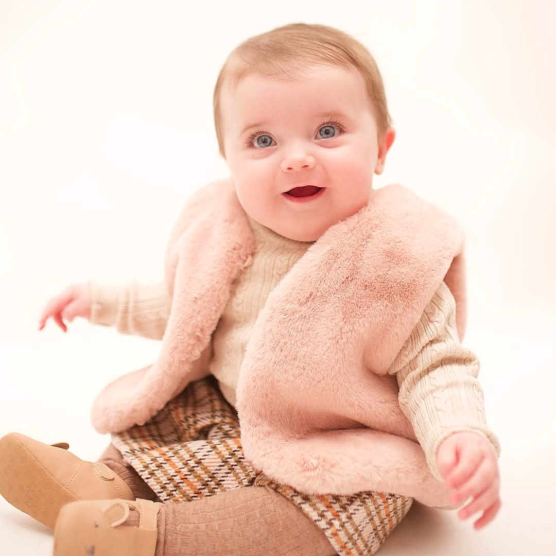 Mya is registered to the contest to win money with this photo: baby, blanket, bodypart, clothing, face, finger, hand, happy, head, hosiery, knitwear, newborn, pants, person, photography, portrait, sitting, smile, sock, sweater