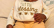 Kyaun joined the competition — help win amazing prizes! baby, child, infant, bib, yellow_pants, white_long_sleeve_shirt, animal_print, cushion, beige, soft, smiling, face, hand, footwear, sitting, indoors, portrait, cute, happy, cozy