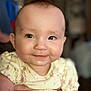 River is registered to the contest to win money with this photo: baby, infant, smile, face, hands, yellow_clothing, cute, portrait, child, person, indoor, soft_light, holding, young_child, skin, expression, happy, closeup, blurred_background, toddler