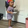 toddler, child, indoor, floor, door, headband, colorful, purple_clothing, socks, person, holding, paper, bag, plastic, curious, standing, home, young_child, flooring, object