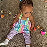toddler, child, carpet, toy_blocks, colorful, indoor, sitting, blue_bow, clothing, purple_pants, white_socks, curly_hair, playtime, floor, young_child, person, cute, casual, home, floor_toys