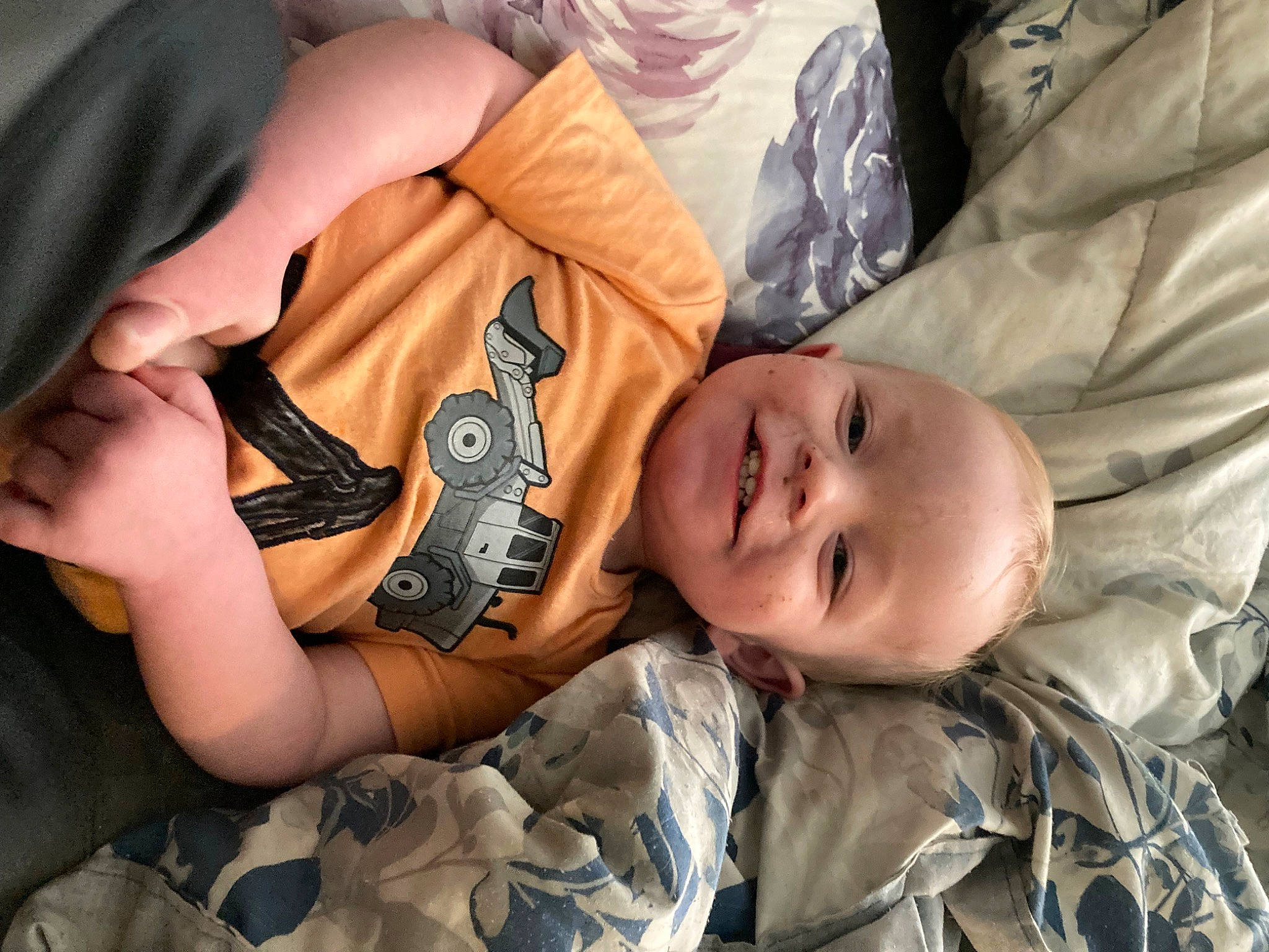 William is registered to the contest to win money with this photo: baby, camouflage, child, comfort, elbow, flesh, gesture, happy, human, joy, linens, mammal, military_camouflage, pattern, person, sitting, sleep, sleeve, smile, toddler