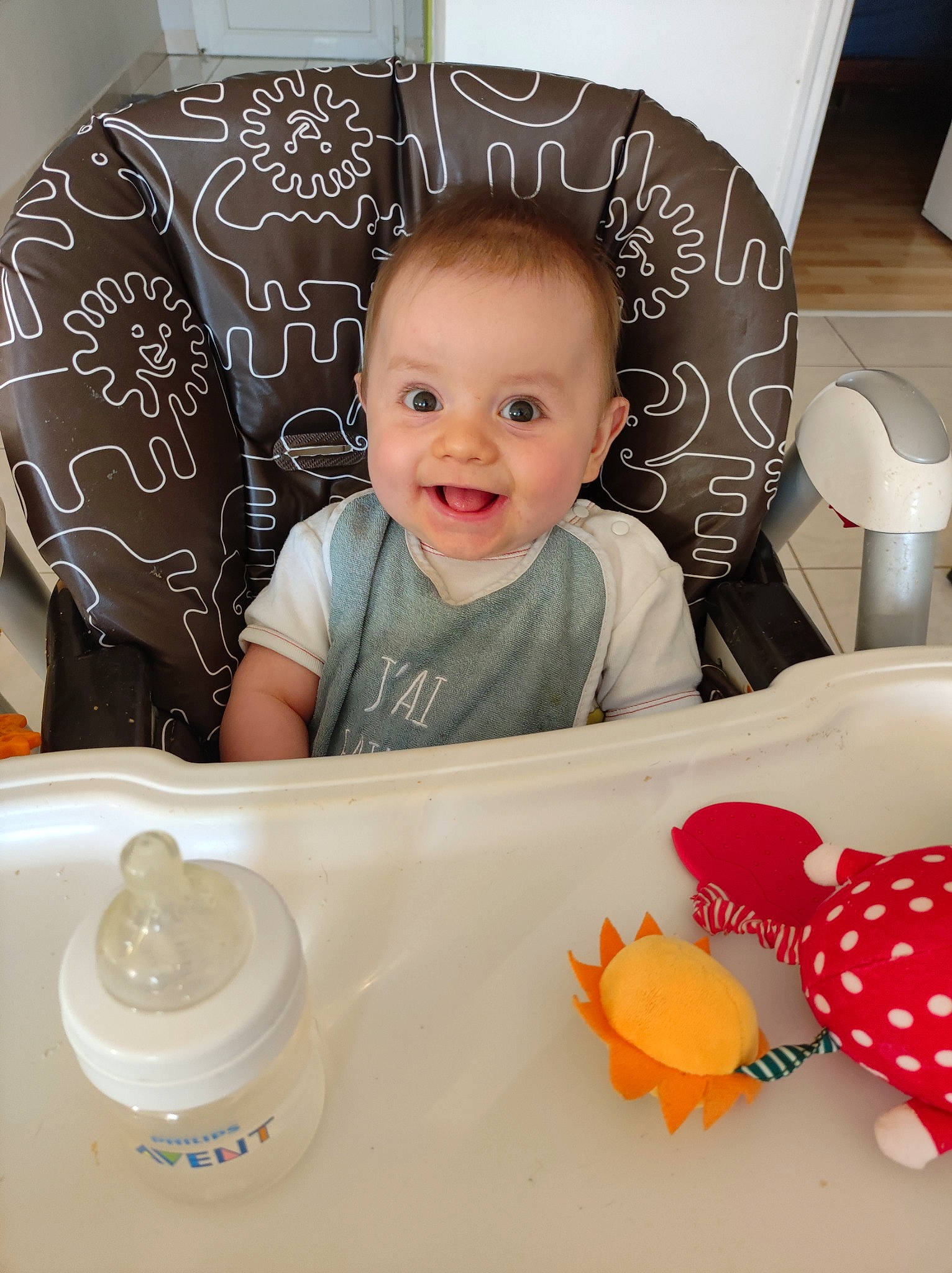 Eliot a rejoint le concours — aidez-le/la à gagner de superbes lots ! baby, baby_toddler_clothing, chair, cheek, child, comfort, dishware, drinkware, happy, home_accessories, joy, laugh, pattern, person, room, sitting, sleeve, smile, t_shirt, table