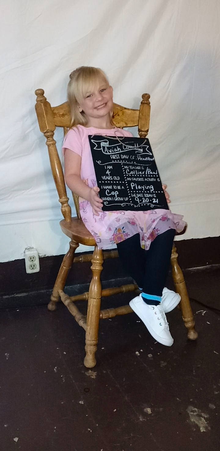 Aviah is registered to the contest to win money with this photo: chair, child, cooking, easel, fashion_accessory, fashion_design, font, fun, handwriting, happy, joy, knee, office_supplies, pattern, person, room, sitting, smile, t_shirt, toddler