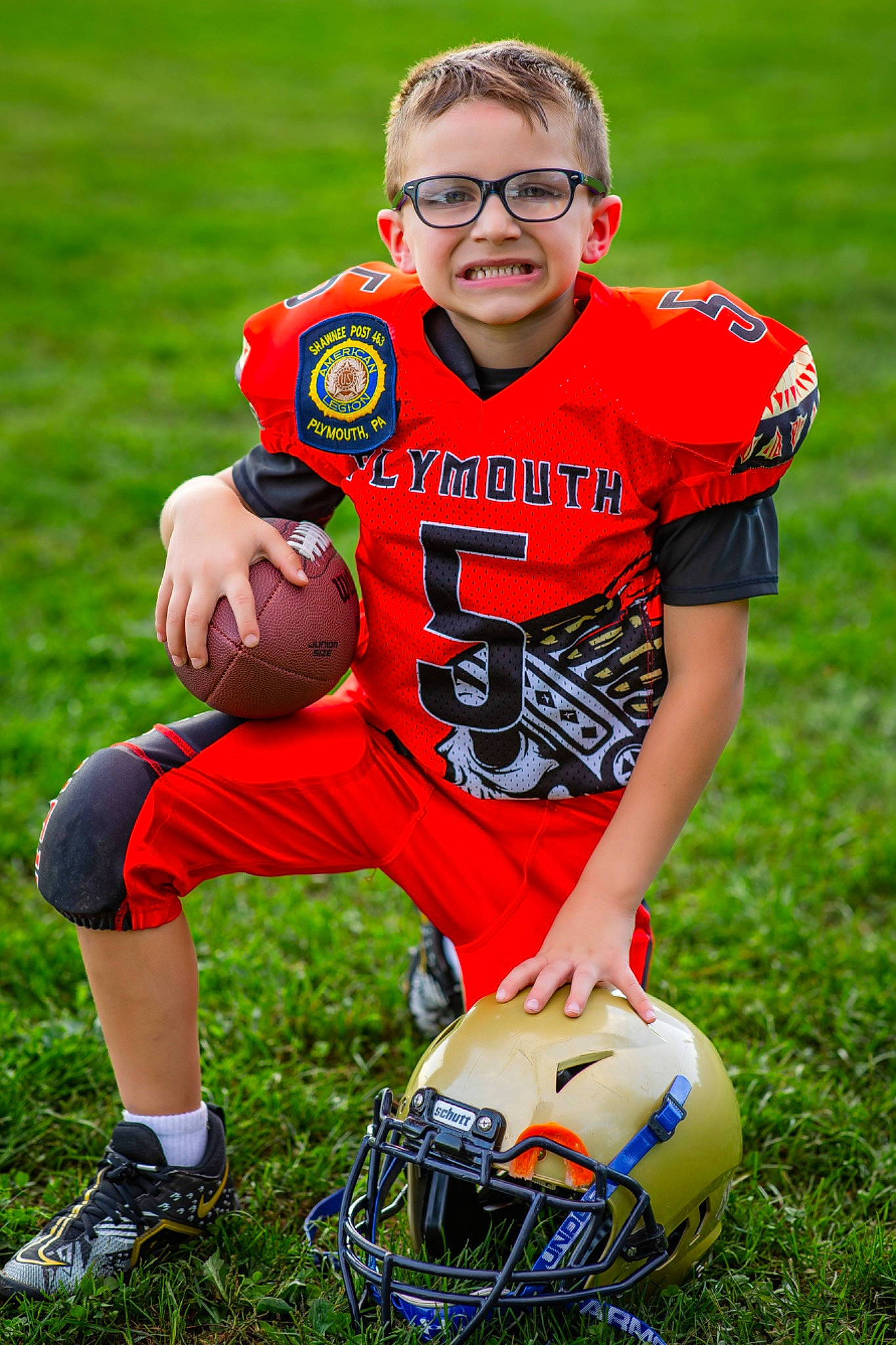 Orion is registered to the contest to win money with this photo: american_football, ball, football, football_equipment, grass, helmet, jersey, joy, mammal, people_in_nature, person, photograph, player, playing_sports, shoe, shorts, soccer_ball, sports_equipment, sports_gear, sports_uniform