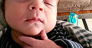 Colton is registered to the contest to win money with this photo: baby, blanket, chair, cozy, cute, face, fingers, furniture, hand, indoor, infant, living_room, newborn, peaceful, person, pillow, portrait, relaxing, sleeping, striped