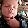 Colton is registered to the contest to win money with this photo: baby, infant, sleeping, hand, blanket, striped, face, fingers, indoor, living_room, chair, pillow, furniture, person, cozy, cute, peaceful, newborn, portrait, relaxing