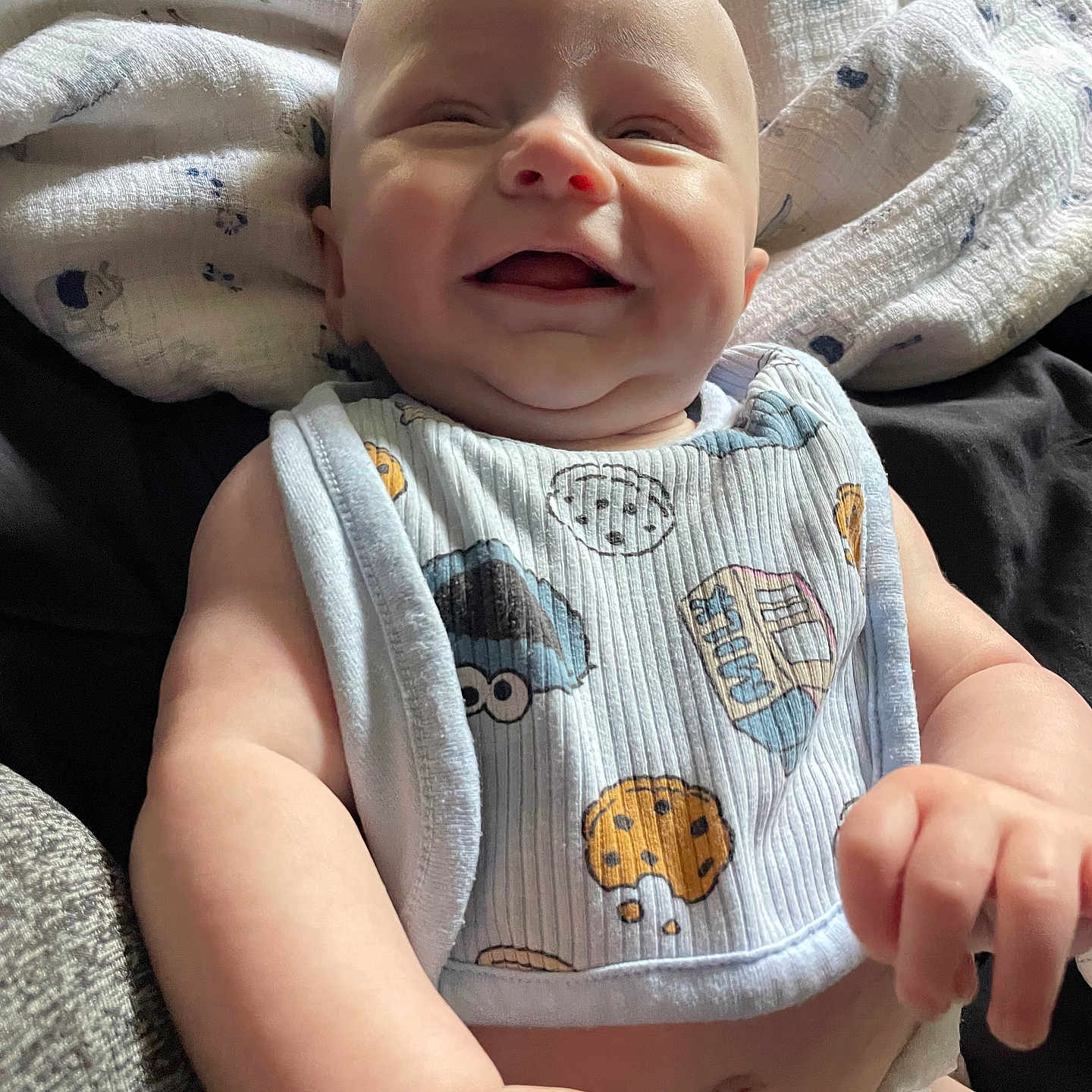 Lucas is registered to the contest to win money with this photo: baby, infant, smiling, laughing, bib, blanket, cute, happy, child, skin, arm, hand, diaper, clothing, closeup, portrait, indoor, soft_light, comfort, joy