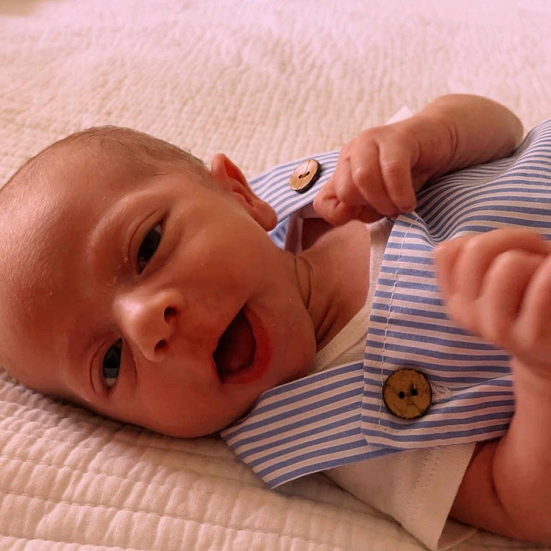 Rylynn joined the competition — help win amazing prizes! baby, bed, closeup, cute, expression, face, hand, human, indoor, infant, lying_down, newborn, portrait, quilt, resting, skin, sleepwear, soft_lighting, striped_clothing, wooden_buttons