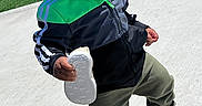 Dnero is registered to the contest to win money with this photo: toddler, child, pacifier, shoe, jacket, green, black, pants, outdoor, concrete, grass, playground, sunny, daylight, walking, footwear, sock, curious, person, young