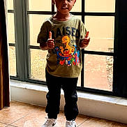 Kingston joined the competition — help win amazing prizes! child, indoor, window, thumbs_up, smile, tshirt, sesame_street, pants, sneakers, tile_floor, natural_light, person, standing, happy, short_hair, casual_clothing, young_child, bright, home, curtain