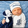 newborn, baby, sleeping, infant, stuffed_animal, plush_toy, blue_blanket, white_outfit, hat, personalized_blanket, cuddling, cute, child, soft_toy, monogram, cozy, portrait, indoors, resting, peaceful