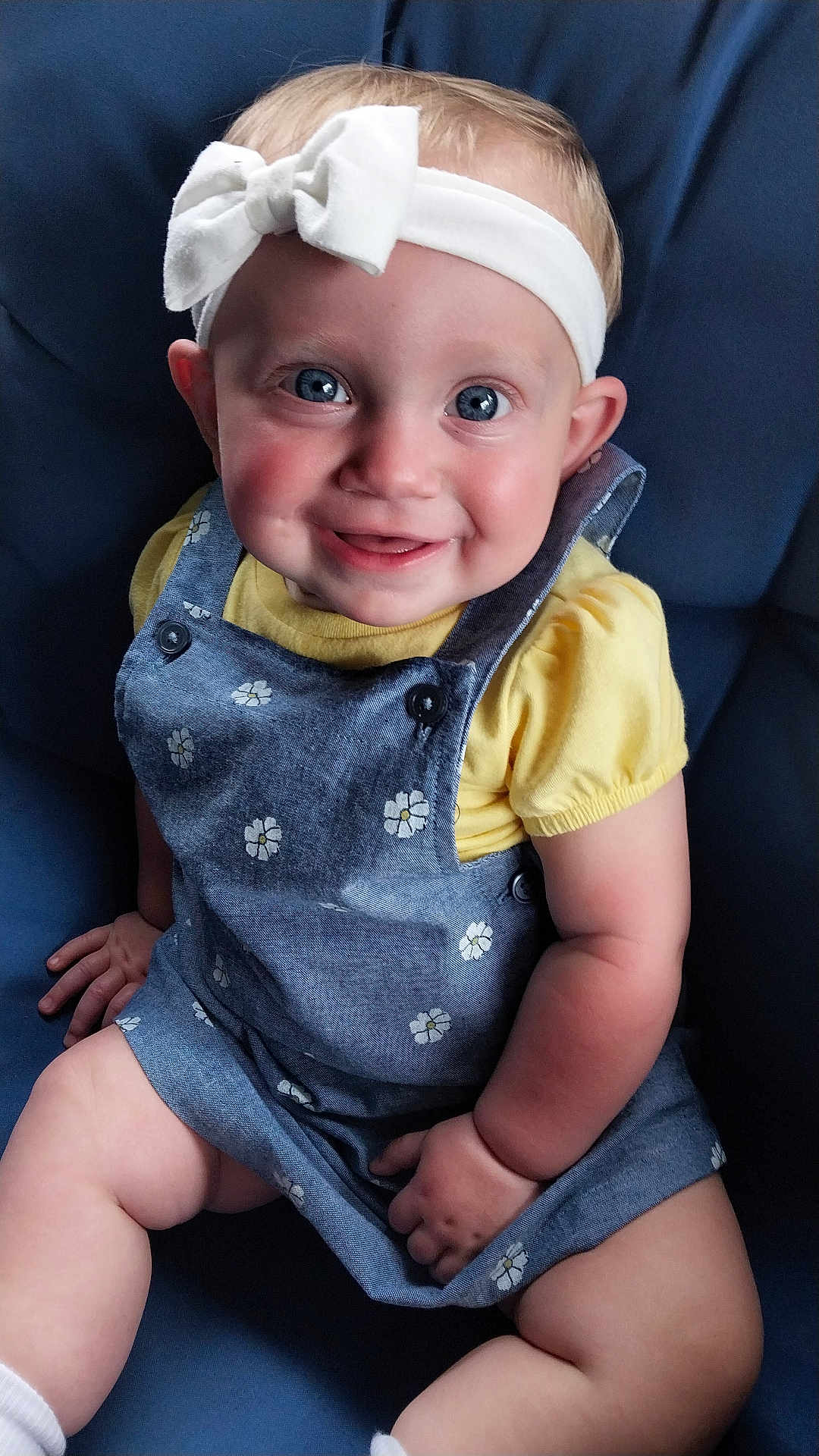 Scarlett joined the competition — help win amazing prizes! baby, child, smiling, blue_eyes, headband, bow, romper, yellow_shirt, sitting, chair, cute, happy, portrait, person, indoor, baby_clothing, infant, skin, face, hands