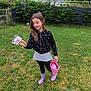 child, girl, outdoor, grass, garden, boots, basket, mug, clothing, smiling, nature, fence, trees, greenery, happy, casual, playful, yard, person, portrait