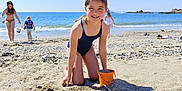Amy participe au concours pour gagner de l'argent avec cette photo : child, girl, beach, sand, bucket, swimsuit, ocean, sea, sky, sunny, playing, summer, shoreline, water, vacation, kids, outdoor, happy, smiling, holiday