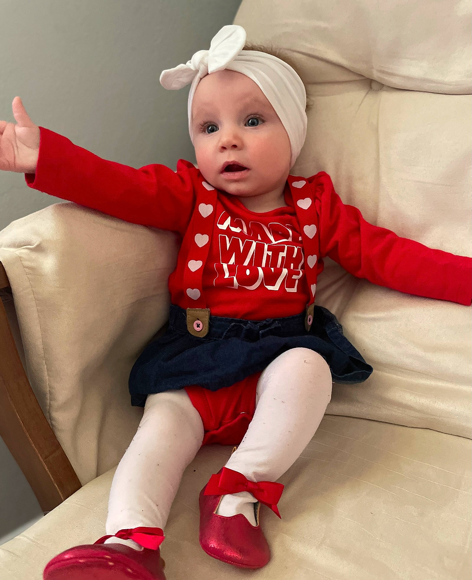 Rowyn is registered to the contest to win money with this photo: baby, baby_toddler_clothing, comfort, costume_hat, face, finger, hat, head, headwear, human_leg, knee, lap, leg, person, pink, red, sleeve, sock, surprise, textile
