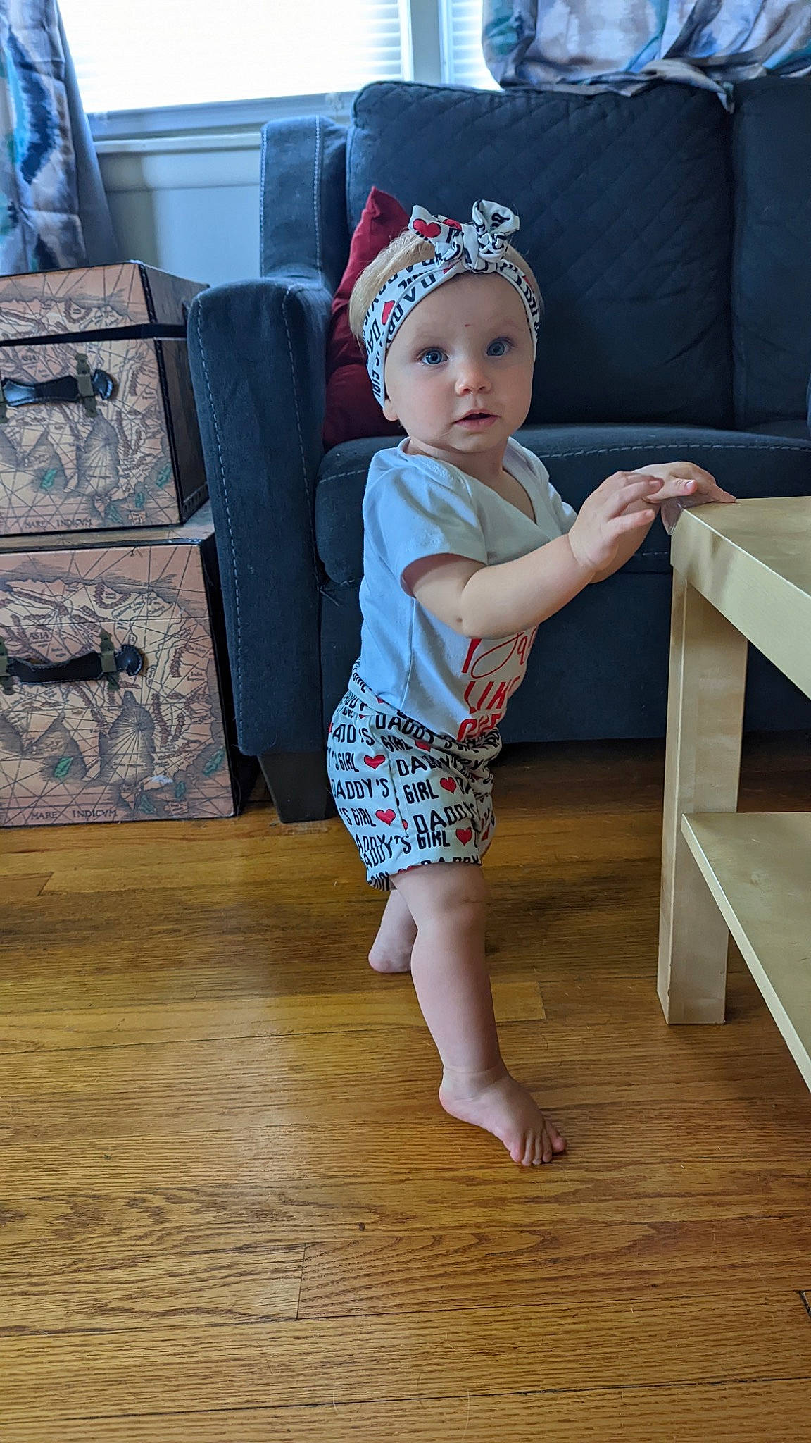 Rowyn is registered to the contest to win money with this photo: baby, baby_toddler_clothing, barefoot, cap, child, costume_hat, floor, flooring, foot, hardwood, headwear, human_leg, pattern, person, sitting, sleeve, t_shirt, thigh, toddler, varnish