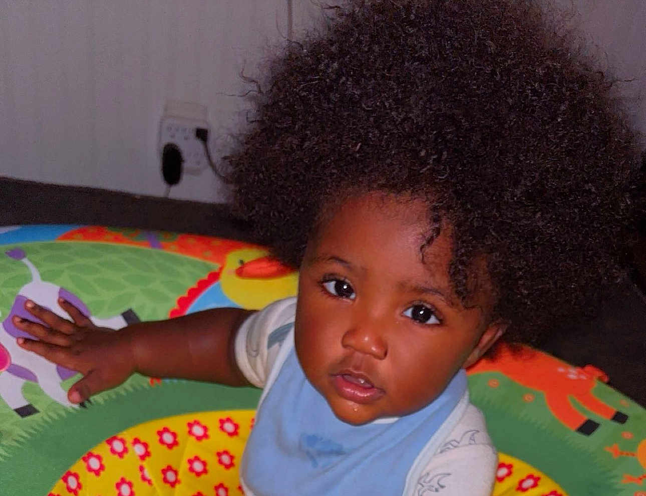 Kaidence is registered to the contest to win money with this photo: toddler, child, afro_hair, play_mat, colorful, indoor, baby, curious, hand, face, wide_eyes, clothing, bib, floor, animal_prints, young_child, portrait, expression, skin_tone, baby_toys