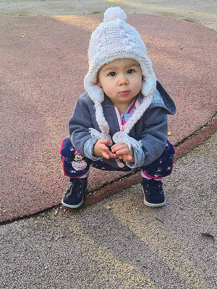 Lysana participe au concours pour gagner de l'argent avec cette photo : asphalt, baby, beanie, cap, child, clothing, eye, fun, grass, headwear, jacket, knit_cap, landscape, pattern, people_in_nature, person, road_surface, sitting, soil, toddler