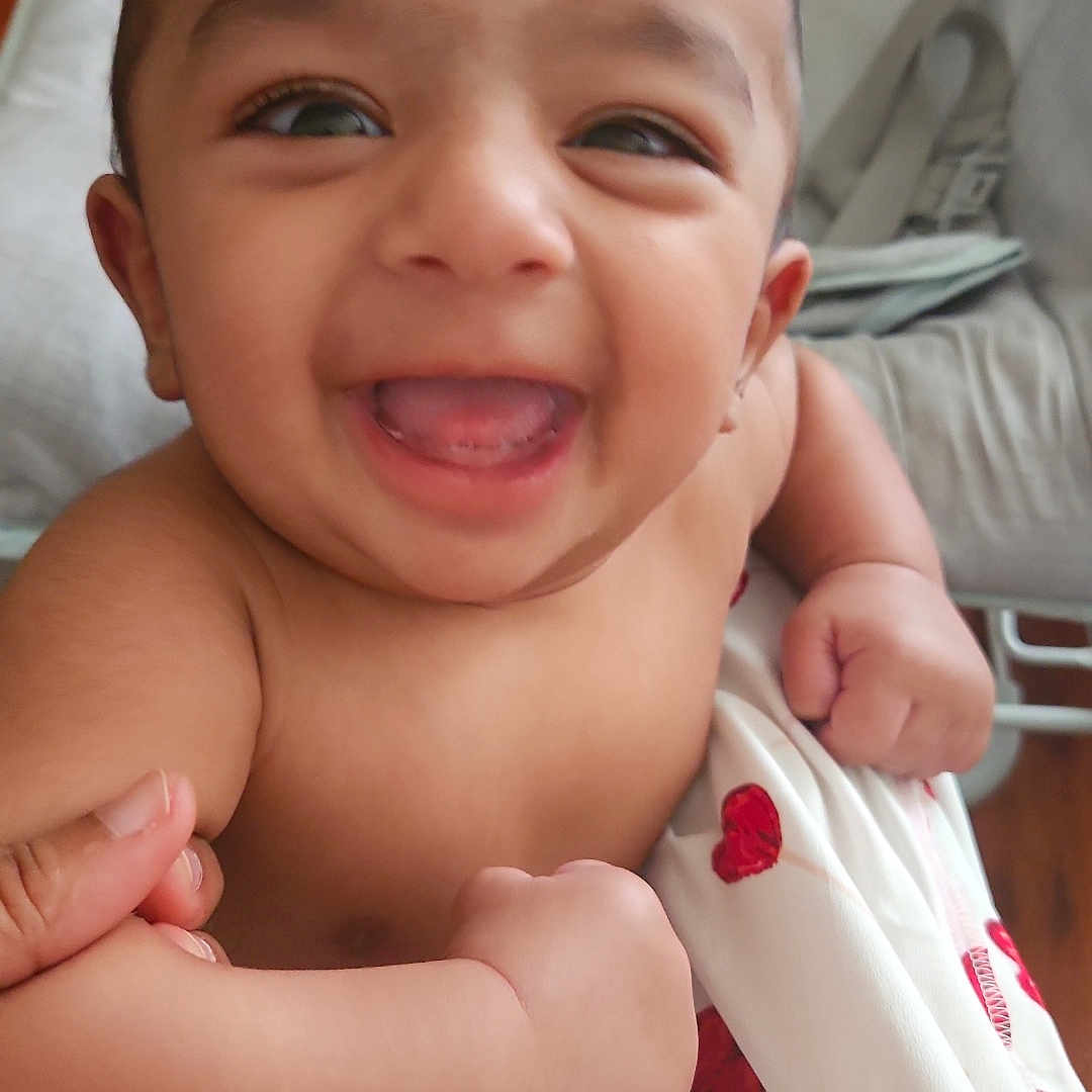 Alzaan is registered to the contest to win money with this photo: baby, blanket, chair, child, closeup, comfort, cushion, cute, diaper, expression, face, hand, happy, hearts, indoors, infant, joy, person, skin, smiling