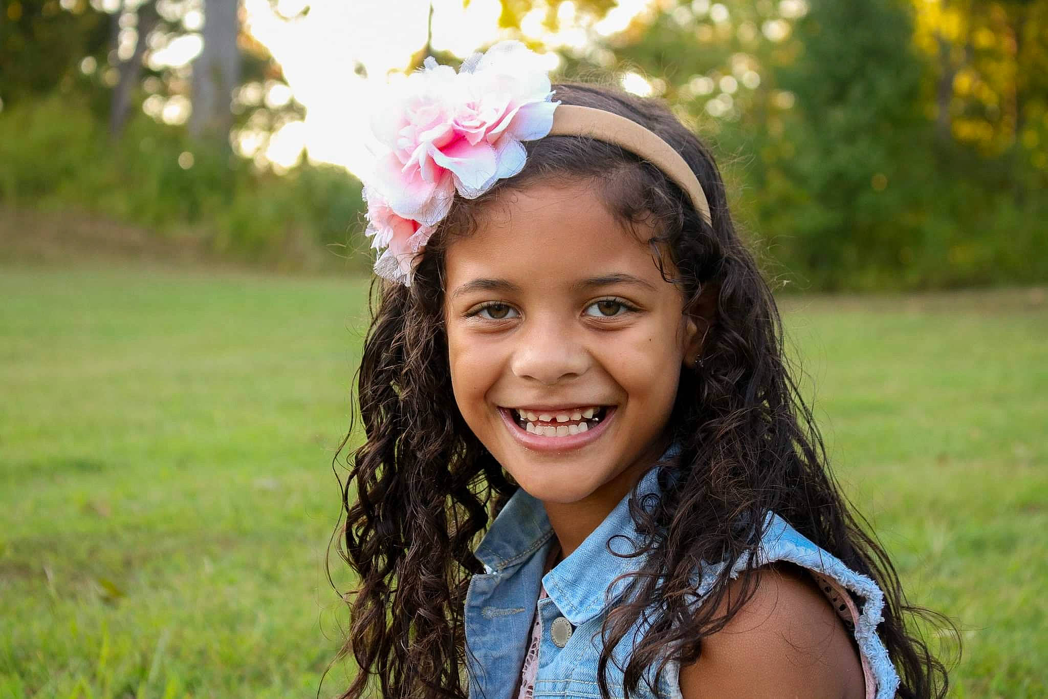 Quiana is registered to the contest to win money with this photo: beauty, brown_hair, child, child_model, facial_expression, fashion_accessory, fun, grass, hair, hair_accessory, hairstyle, happy, headband, headgear, joy, laugh, long_hair, people_in_nature, person, photography