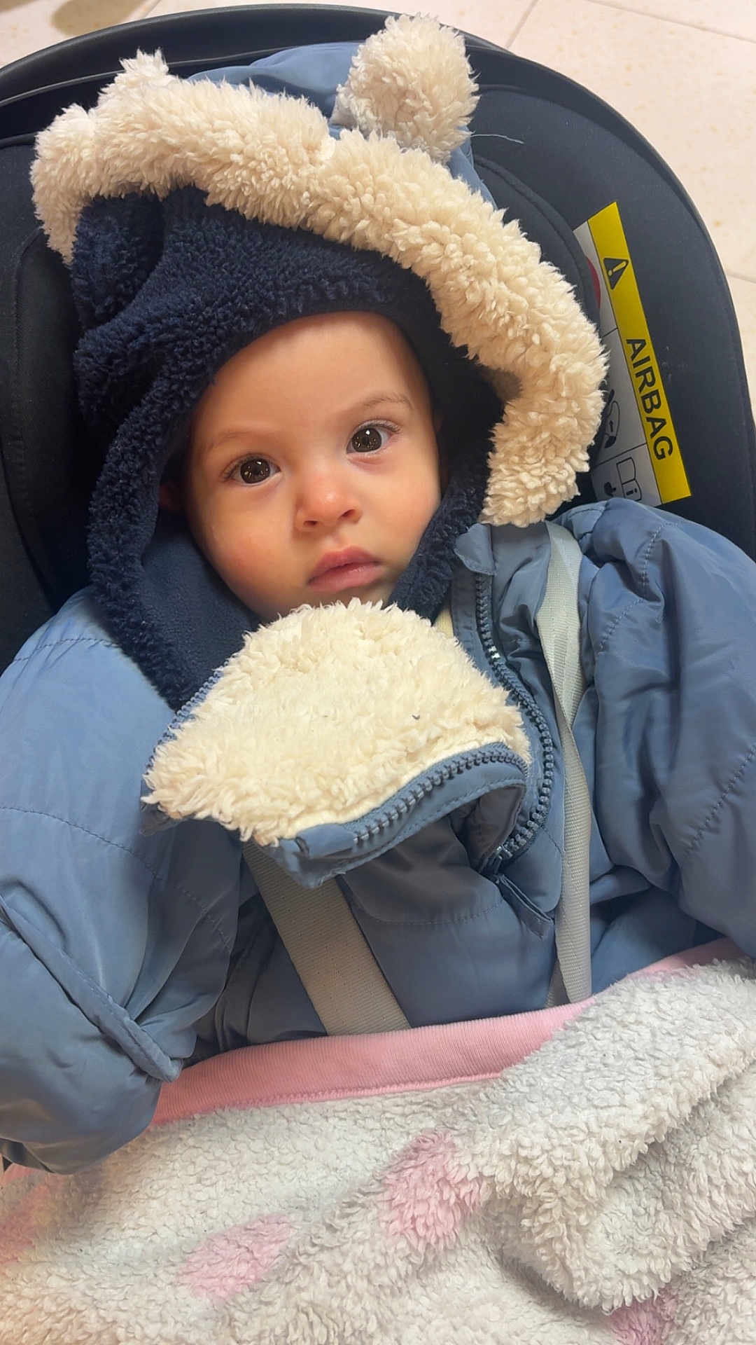 Imran participe au concours pour gagner de l'argent avec cette photo : baby, child, car_seat, jacket, hood, blanket, fur_trim, face, eyes, clothing, warm, indoor, seatbelt, infant, portrait, cute, winter_wear, soft_texture, close_up, sitting