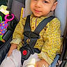 Zayan joined the competition — help win amazing prizes! toddler, child, car_seat, seatbelt, yellow_shirt, white_pants, toy, car_interior, face, sitting, cute, expression, indoors, safety, daytime, clothing, hands, head, portrait, baby