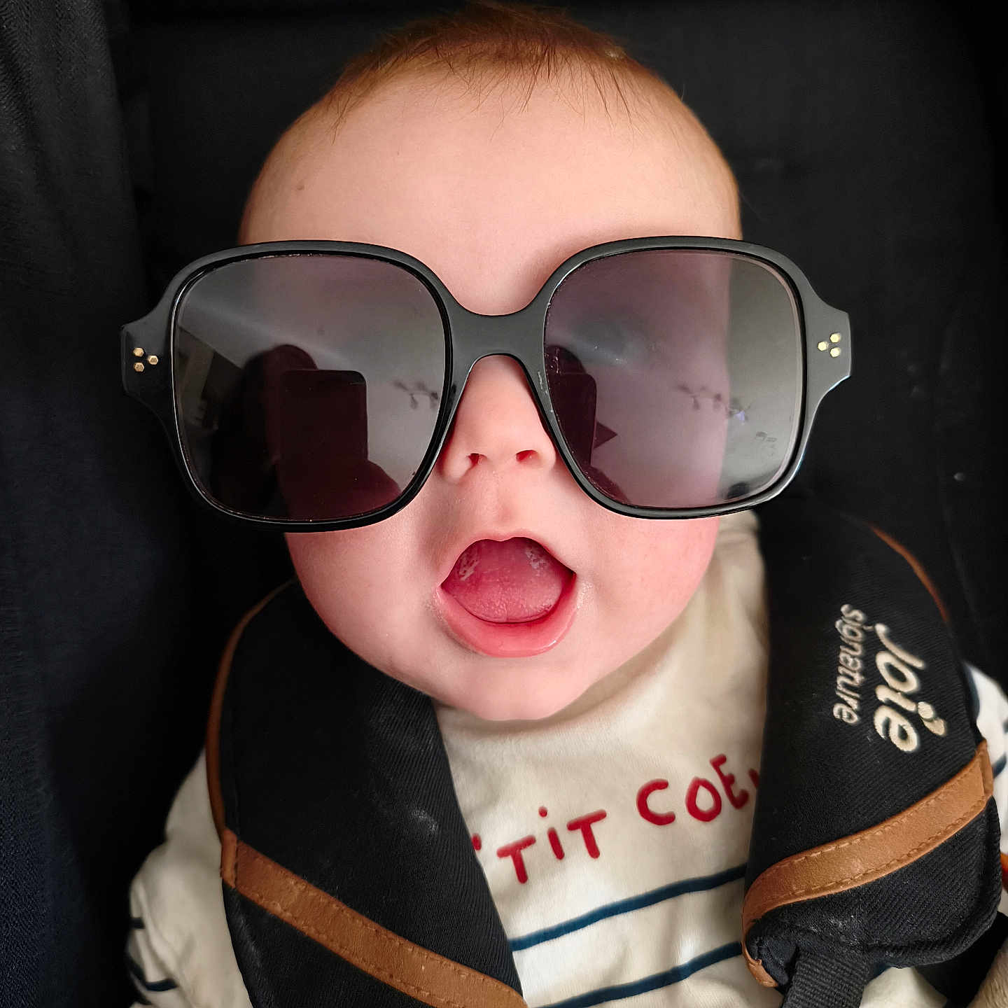 Gabriel a rejoint le concours — aidez-le/la à gagner de superbes lots ! baby, child, sunglasses, car_seat, seat_belt, open_mouth, striped_shirt, face, head, infant, cute, black, clothing, safety, expression, person, portrait, young, accessory, close_up