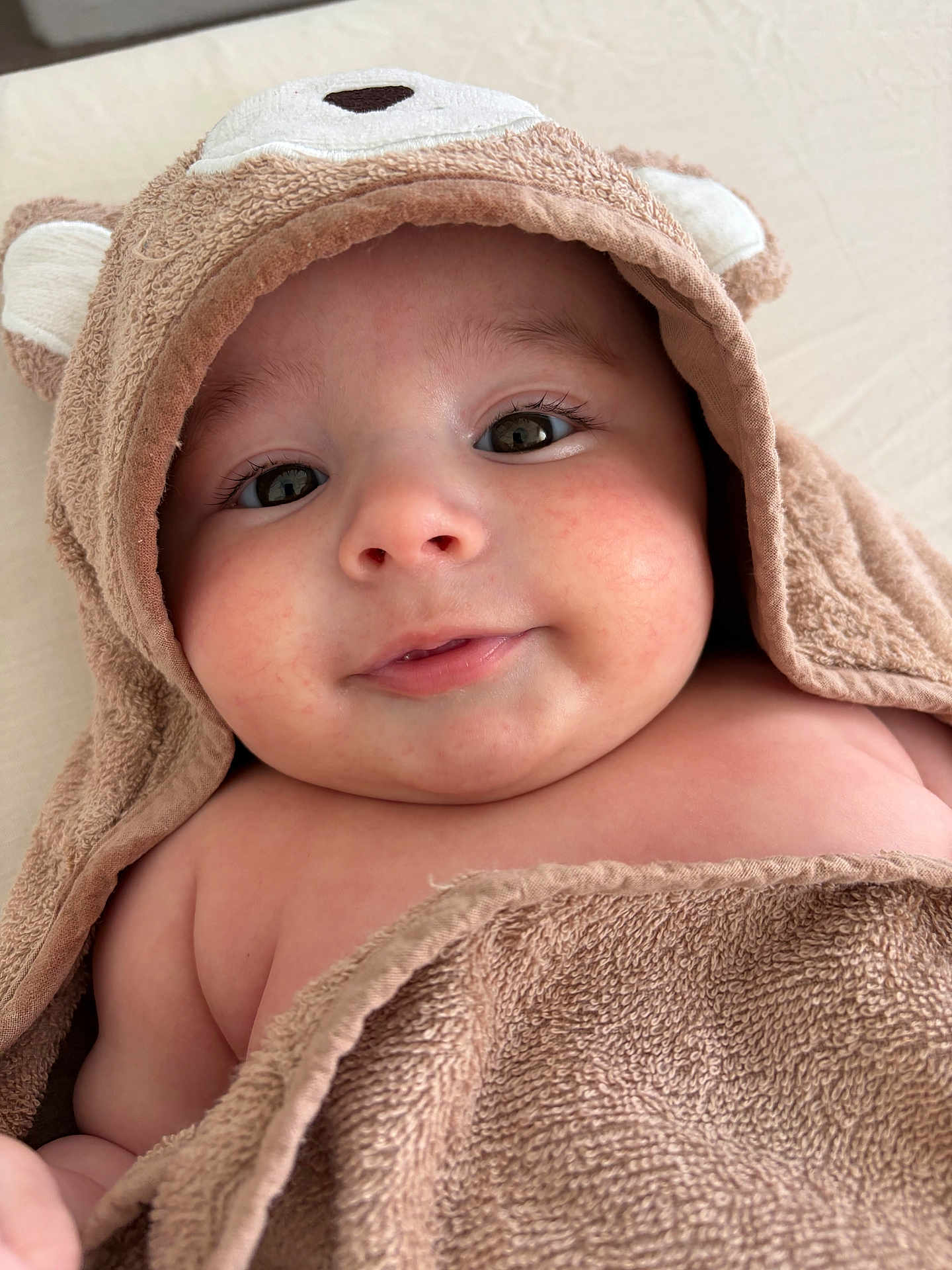 Nahïl a rejoint le concours — aidez-le/la à gagner de superbes lots ! adorable, baby, brown, child, closeup, comfortable, cute, expression, eyes, face, hood, infant, portrait, skin, smile, soft, texture, towel, warm, young