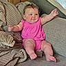 baby, infant, pink_clothing, couch, blanket, pillow, indoors, smiling, happy, child, cute, soft_texture, cozy, plush, furniture, person, skin, legs, arms, head