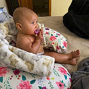 Vivienne joined the competition — help win amazing prizes! baby, infant, pacifier, blanket, floral_pattern, cushion, bed, indoors, child, person, skin, head, foot, hand, door, wood, fabric, comfort, rest, relaxation