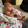 baby, infant, pacifier, blanket, floral_pattern, cushion, bed, indoors, child, person, skin, head, foot, hand, door, wood, fabric, comfort, rest, relaxation
