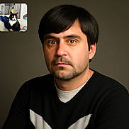 Bandit joined the competition — help win amazing prizes! man, portrait, face, beard, brown_eyes, black_hair, sweater, indoor, cat, tuxedo_cat, living_room, couch, furniture, cozy, closeup, expression, casual_clothing, home, pet, animal