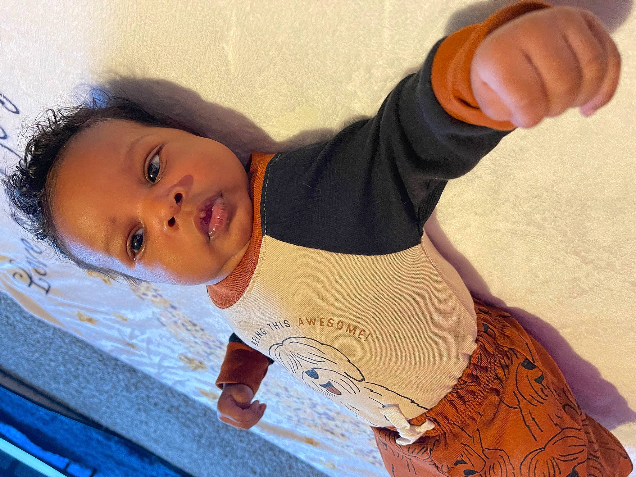 Zayne is registered to the contest to win money with this photo: arm, baby, chest, child, elbow, eyelash, finger, fun, gesture, hand, happy, human_body, human_leg, joint, person, skin, sleeve, toddler, waist, wood