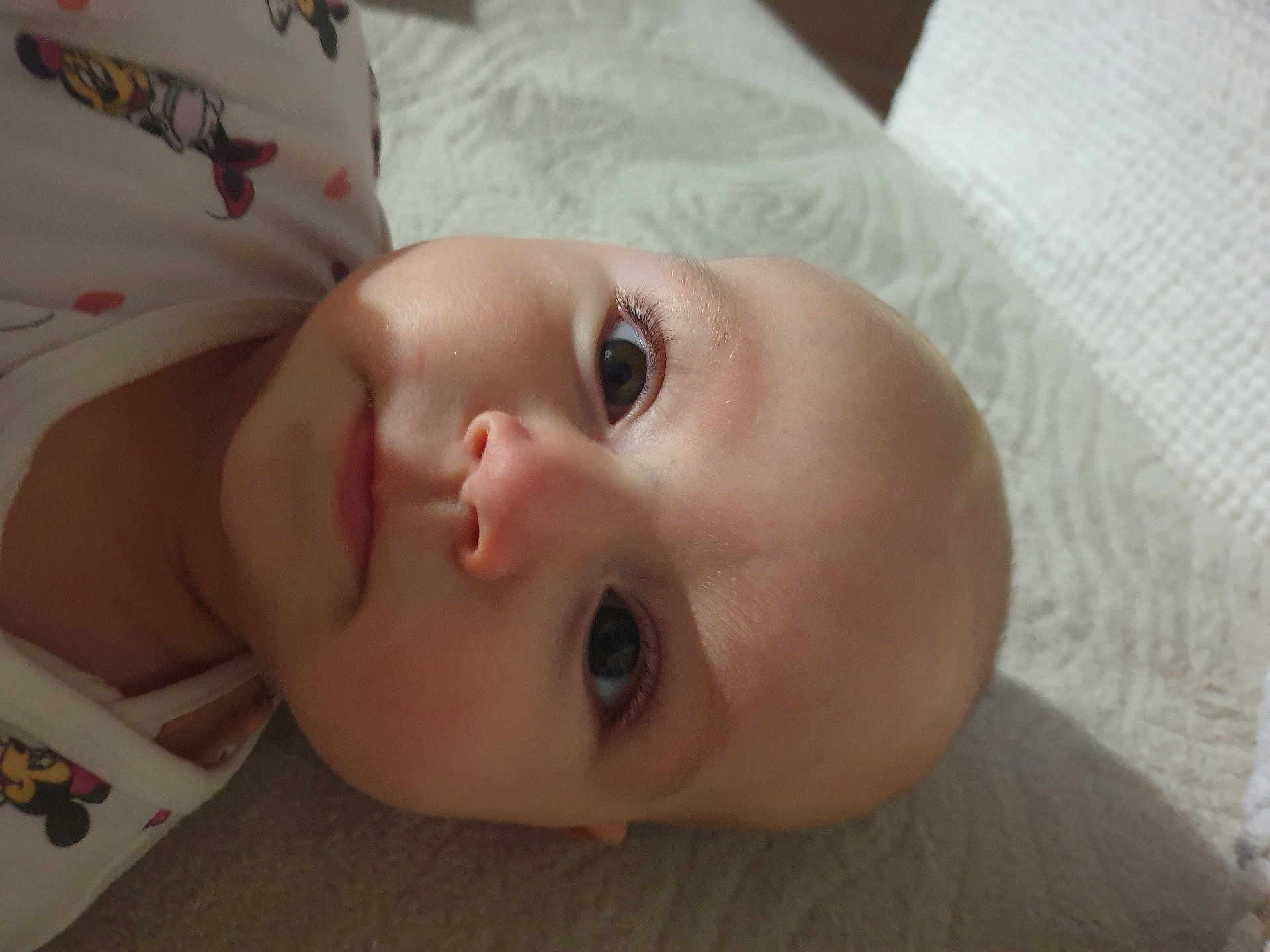 Mila participe au concours pour gagner de l'argent avec cette photo : baby, face, infant, closeup, lying_down, cute, cartoon_clothing, soft_surface, skin, eyes, expression, child, portrait, head, young, person, indoors, sleepwear, apparel, resting