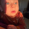 Lissandro participe au concours pour gagner de l'argent avec cette photo : baby, child, face, hand, blue_eyes, shadow, sunlight, orange_clothing, cozy, indoor, portrait, curious, young, skin, expression, closeup, infant, person, warm_light, holding