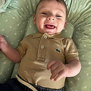 Lissandro a rejoint le concours — aidez-le/la à gagner de superbes lots ! baby, child, smiling, polo_shirt, green_cushion, happy, infant, portrait, cute, lying_down, clothing, patterned, fabric, hand, face, tongue_out, indoor, young_child, casual, denim_pants