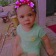 Amoni is registered to the contest to win money with this photo: toddler, child, porch, outdoor, wooden_floor, green_clothing, sun_graphic, headband, purple_hearts, sparkles, curly_hair, american_flag, trees, car, daylight, expression, sitting, shoe, person, playful_effects