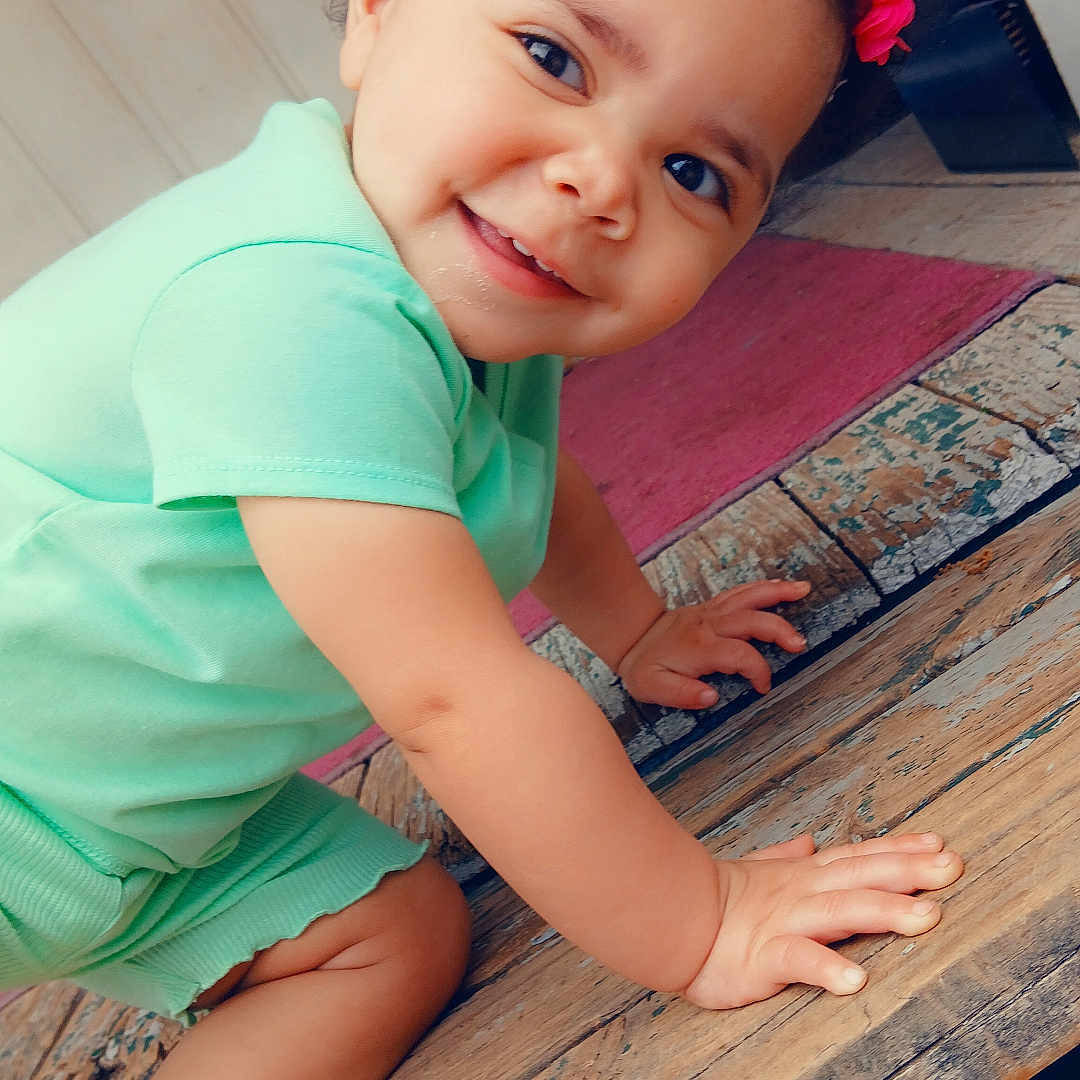 Amoni joined the competition — help win amazing prizes! baby_shoes, bright, child, closeup, crawling, curly_hair, cute, door, floor, happy, headband, indoors, mint_green_clothing, person, pink_flower, playful, portrait, smiling, toddler, wooden_surface
