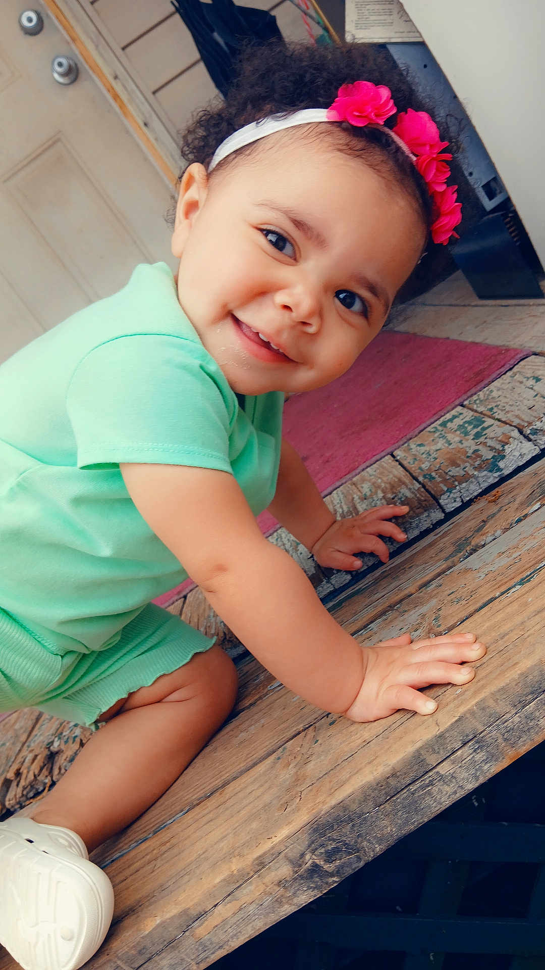 Amoni joined the competition — help win amazing prizes! toddler, child, smiling, crawling, headband, pink_flower, mint_green_clothing, wooden_surface, indoors, floor, door, happy, cute, baby_shoes, curly_hair, person, portrait, closeup, playful, bright