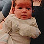 Alexis is registered to the contest to win money with this photo: baby, infant, blanket, clothing, person, face, hand, sitting, indoors, soft_lighting, curly_hair, onesie, wrapped, comfort, holding, portrait, newborn, warm, resting, cute