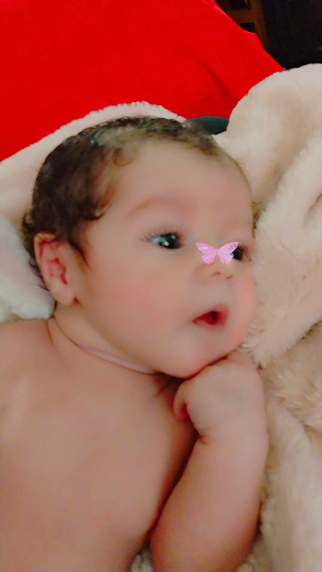 Alexis is registered to the contest to win money with this photo: baby, infant, face, skin, hand, blanket, soft_texture, curious, lying_down, indoors, cute, child, newborn, closeup, portrait, filter, butterfly, pink, warm_colors, expression