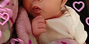 Alexis is registered to the contest to win money with this photo: baby, blanket, infant, face, hand, curious, surprised, pink_hearts, soft_texture, close_up, indoors, cute, child, person, young, cozy, warm, wrapped, expression, portrait