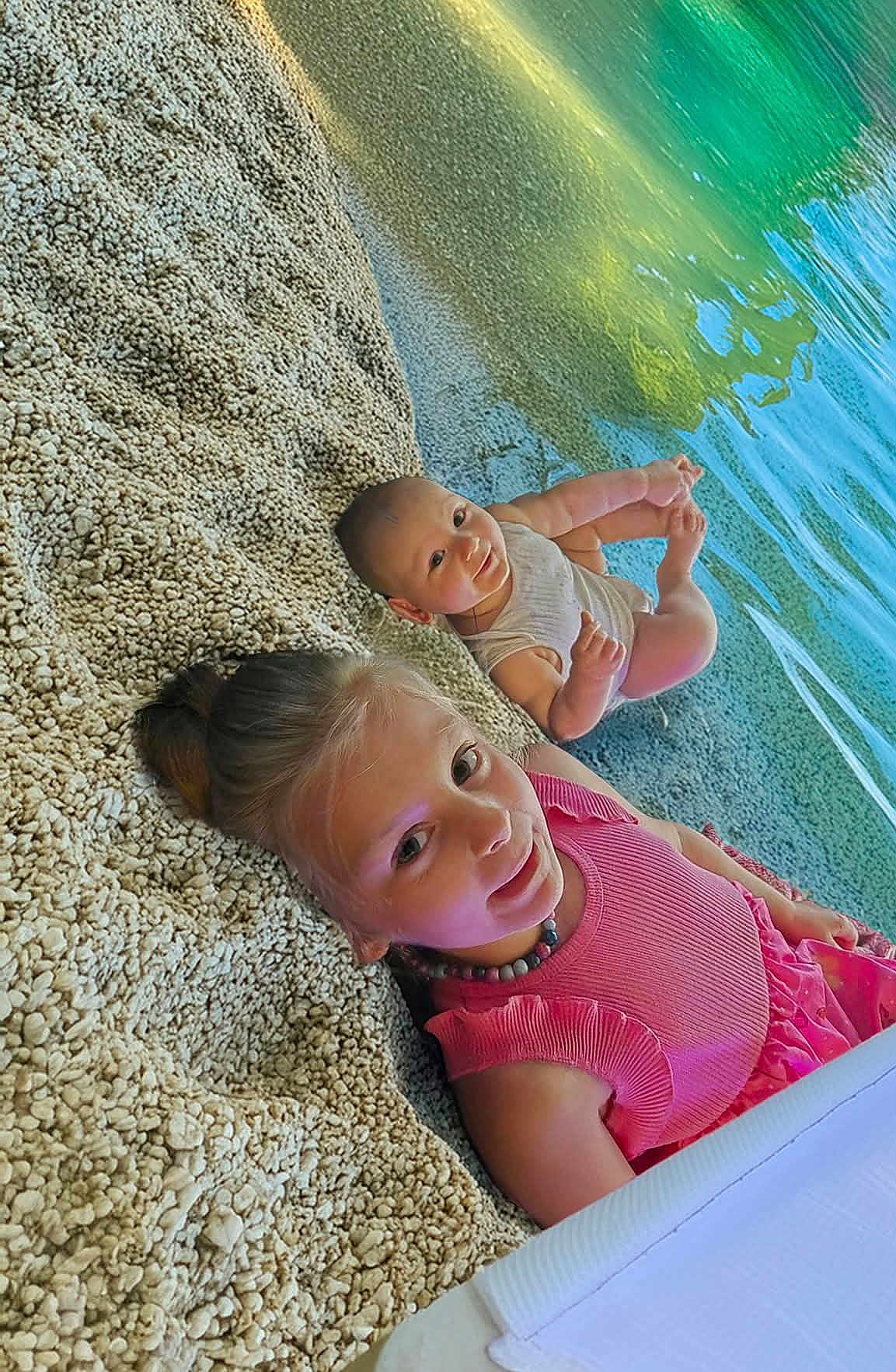 Ethan Et Lena participe au concours pour gagner de l'argent avec cette photo : child, baby, pebble_beach, water, lake, smile, pink_dress, onesie, outdoor, nature, happy, portrait, summer, siblings, relaxing, sunlight, cute, playful, family, vacation
