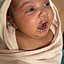 baby, infant, face, expression, mouth_open, wrapped, blanket, hood, skin, cute, newborn, person, child, soft, indoors, light, portrait, closeup, happy, curious