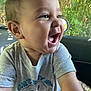 baby, child, smiling, happy, face, person, tshirt, short_sleeve, car_interior, window, greenery, natural_light, portrait, cute, skin, arm, expression, sitting, young_child, indoors