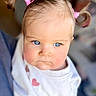 baby, child, blue_eyes, pigtails, pink_hair_ties, white_shirt, heart_prints, close_up, portrait, indoor, cute, adorable, soft_lighting, expression, person, infant, young_child, face, skin, hair